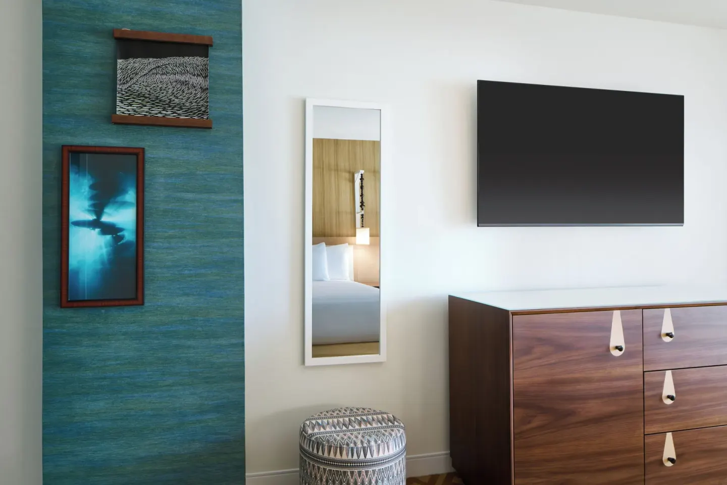 City View room dresser, wall-mounted TV, mirror, and artwork at Waikiki Malia.