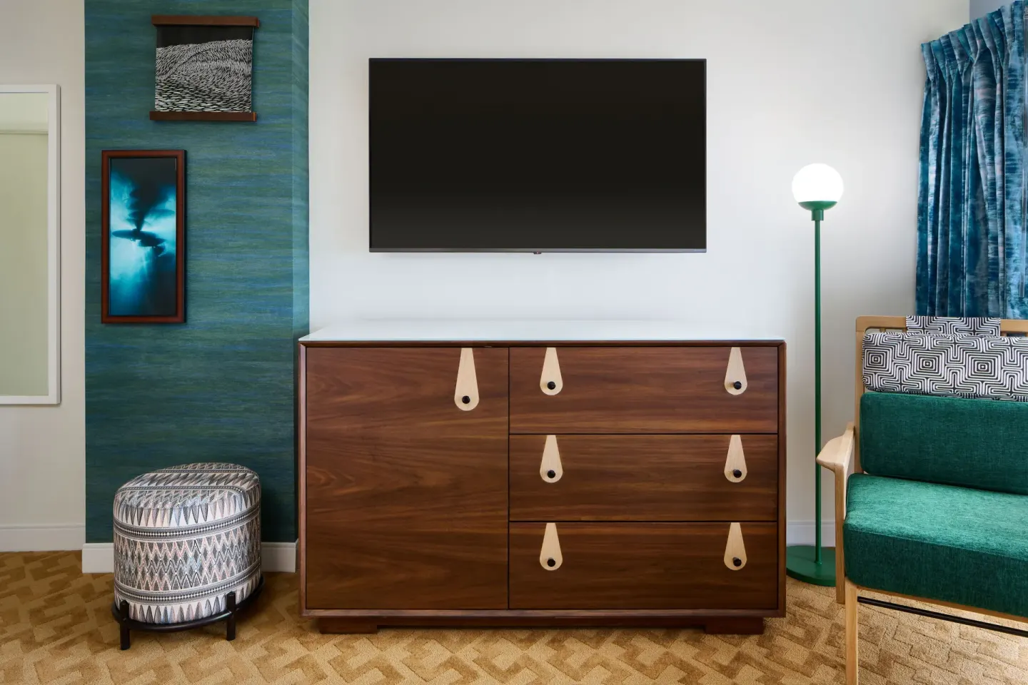 Partial Ocean View room seating area with TV, dresser, chair, and ottoman at Waikiki Malia.