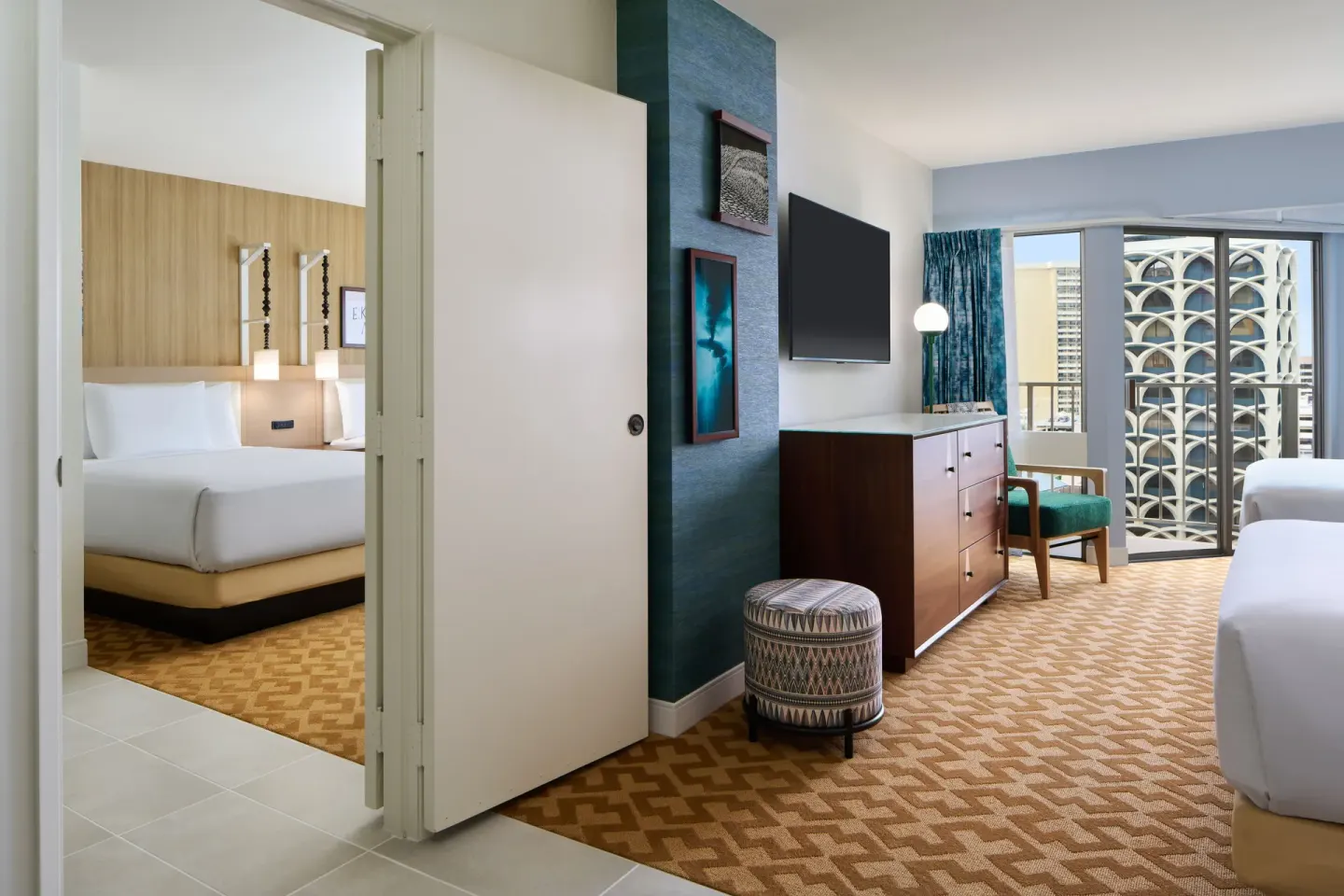 Partial Ocean View room with two beds, dresser, TV, and balcony at Waikiki Malia.