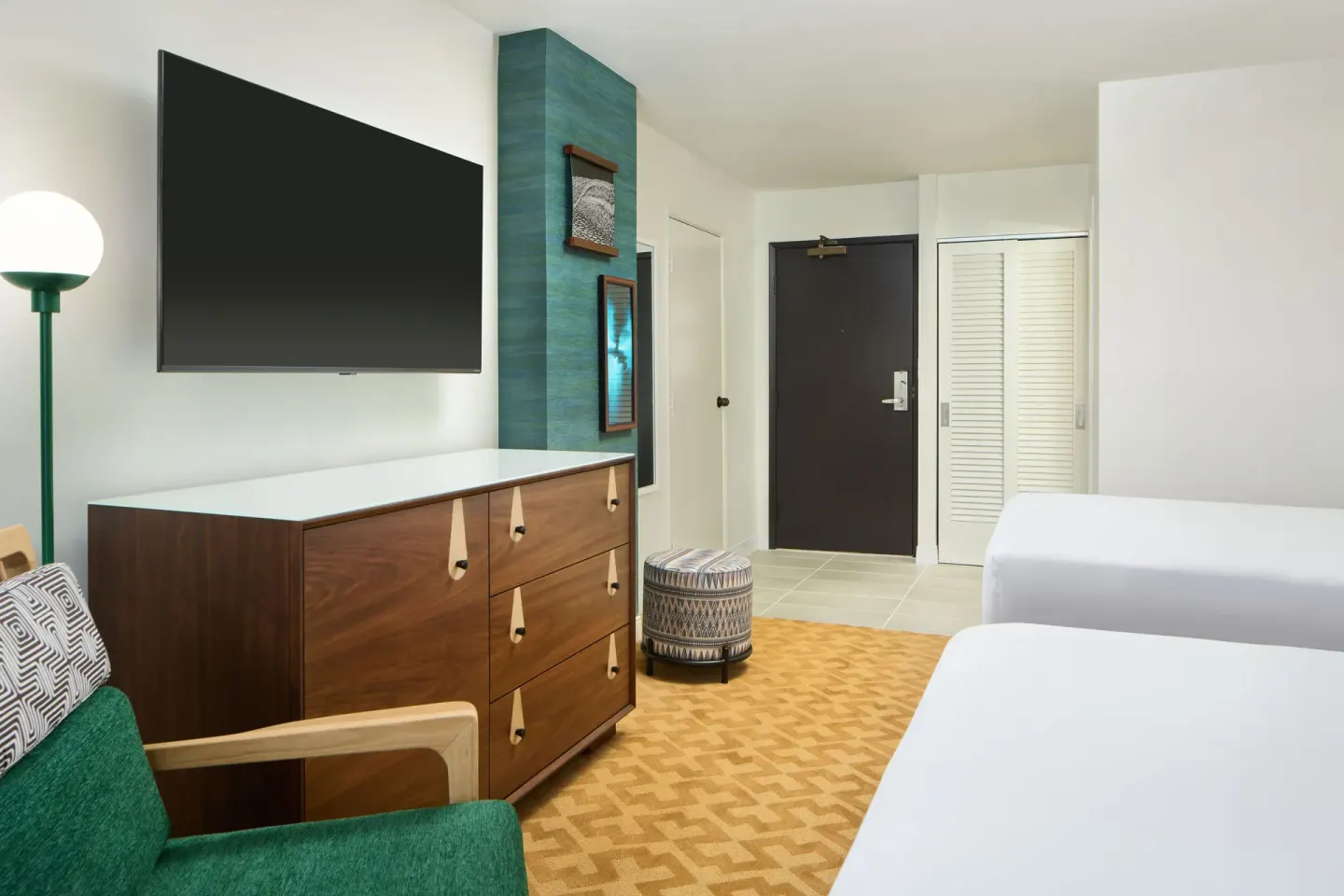 Partial Ocean View room with two beds, TV, dresser, and entry area at Waikiki Malia.