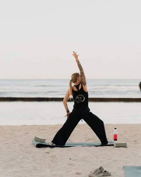 Beach yoga session on the sand with the ocean behind at Waikiki Resort Hotel.