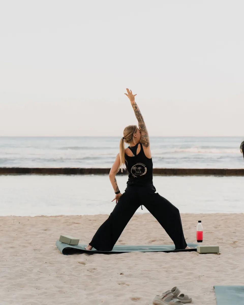 Beach yoga session on the sand with the ocean behind at Waikiki Resort Hotel.