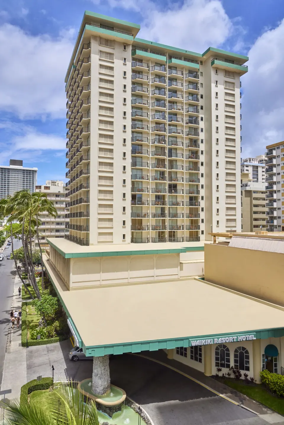 Daytime exterior tower with balconies and entrance canopy at Waikiki Resort Hotel.