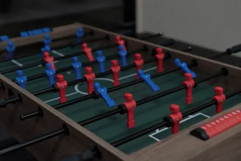 A close-up shows red and blue foosball figures on a table at Waikiki Resort Hotel.