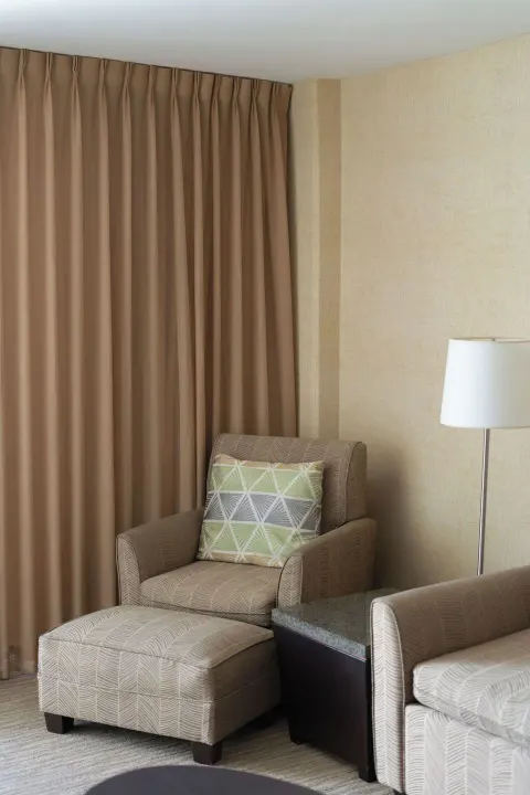 Guest room seating area with armchair and ottoman at Waikiki Resort Hotel.