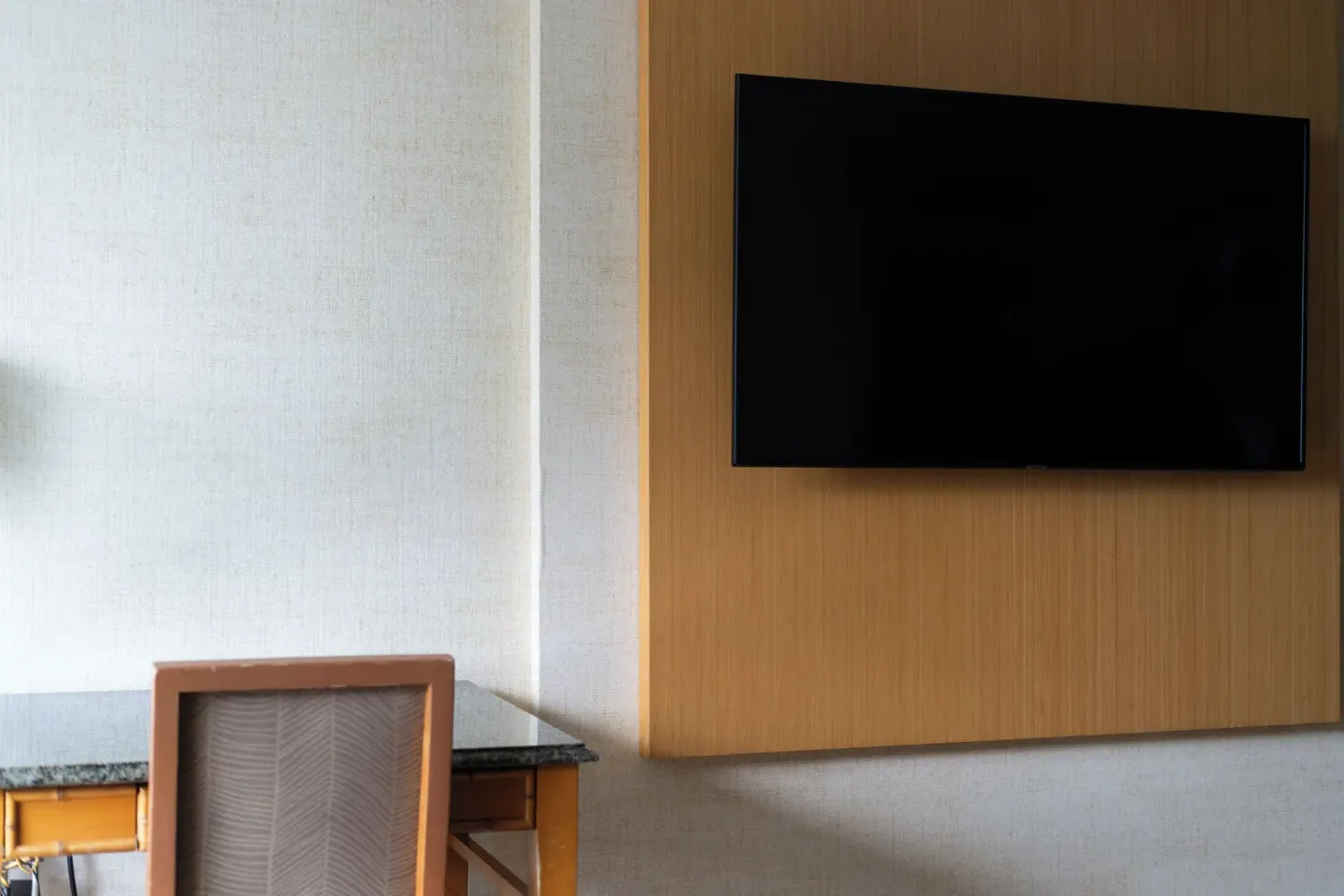Wall-mounted television beside a desk area in a guest room at Waikiki Resort Hotel.