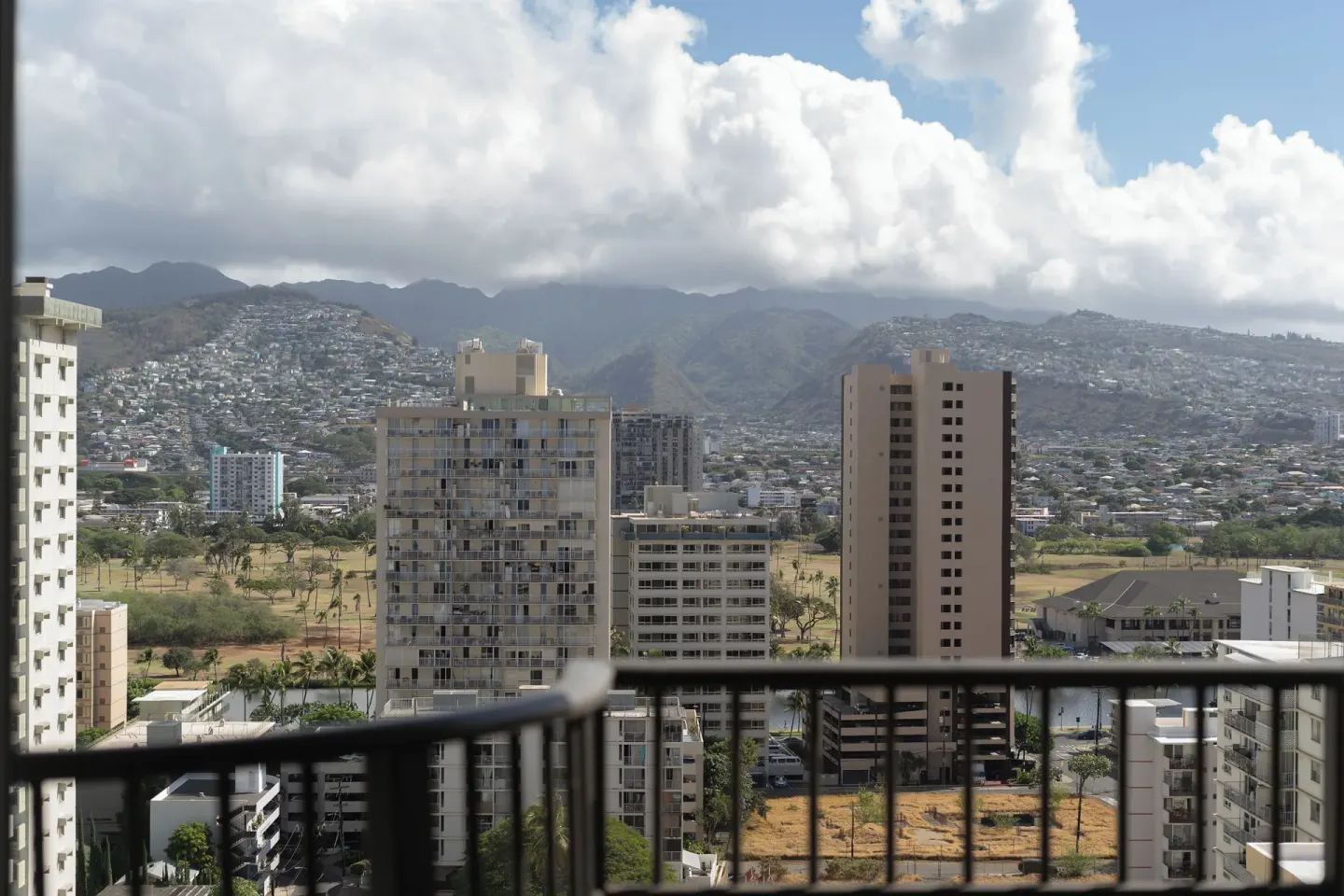 Mountain and city view seen over a balcony rail at Waikiki Resort Hotel.