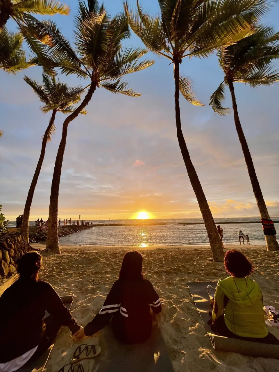 Sunset over Waikiki Resort Hotel framed by palm trees near Waikiki Resort Hotel.