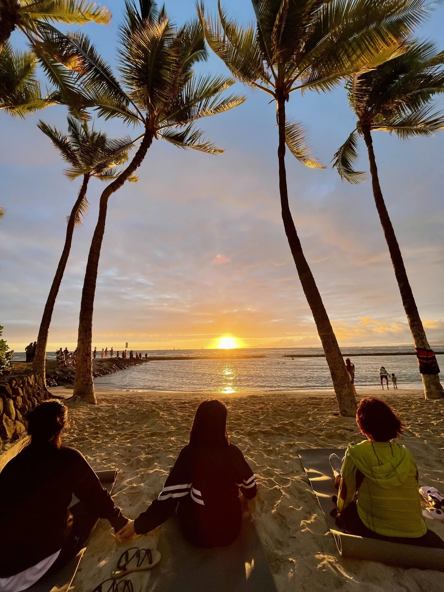 Sunset over Waikiki Resort Hotel framed by palm trees near Waikiki Resort Hotel.