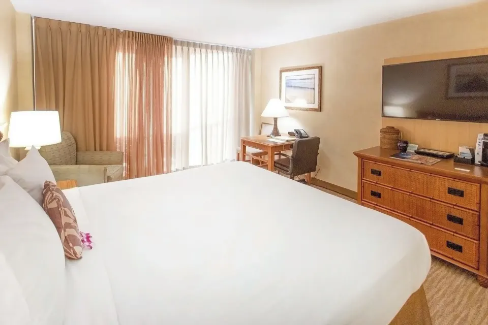City View room with king bed, dresser, TV, desk, and chair at Waikiki Resort Hotel.