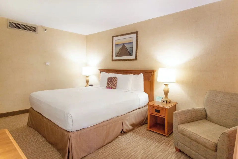 City View room with king bed, bedside lamps, and armchair at Waikiki Resort Hotel.