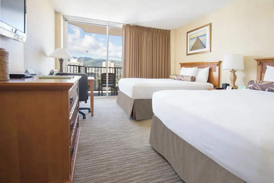 City View room with two beds, desk, dresser, and balcony at Waikiki Resort Hotel.