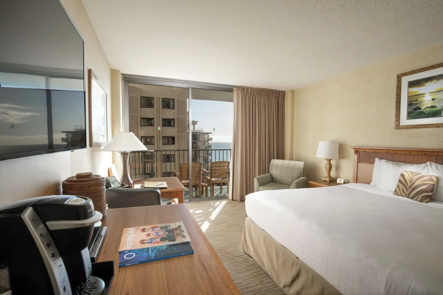 Partial Ocean View room with king bed, desk, chair, and balcony at Waikiki Resort Hotel.