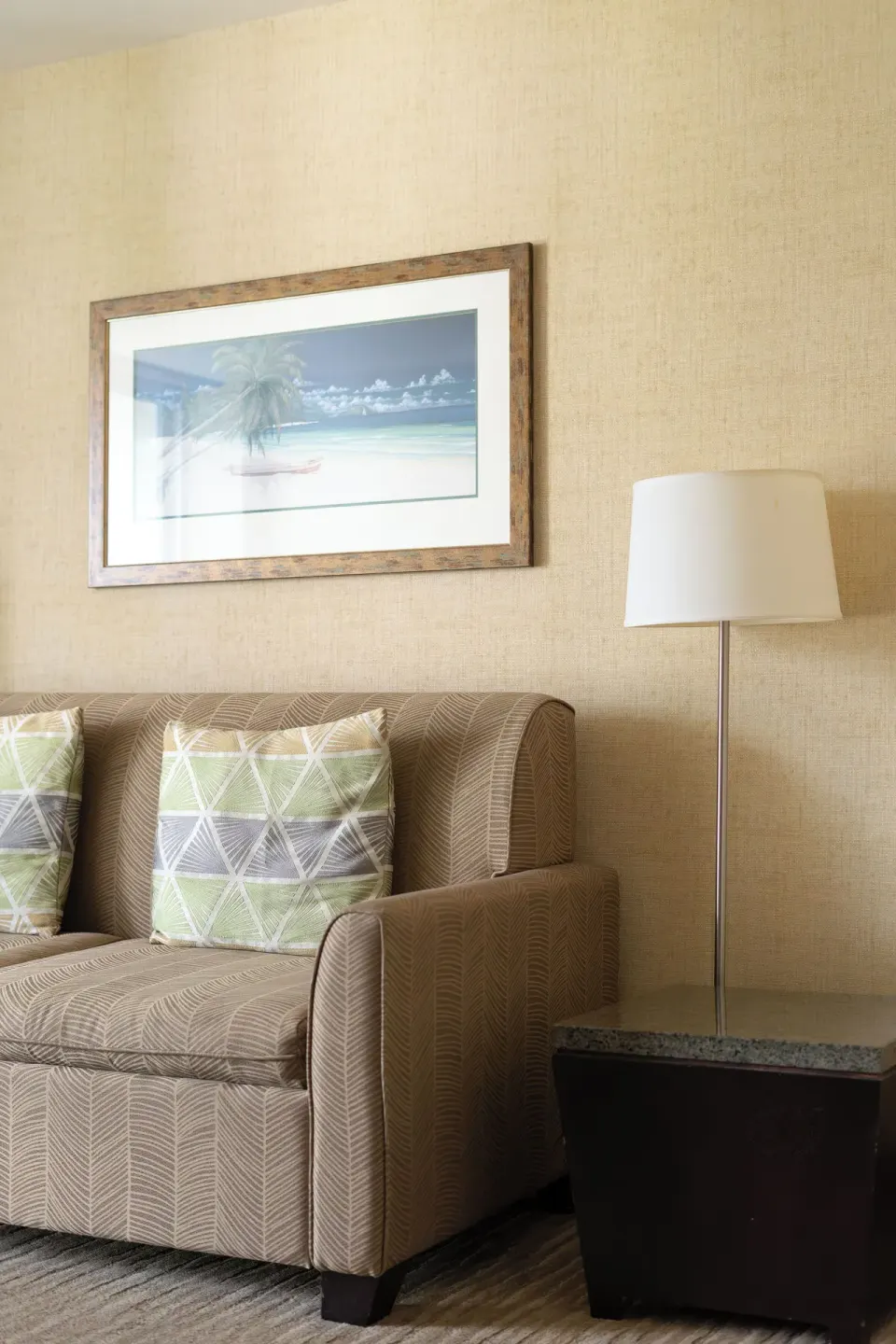 Suite Mountain View sofa, side table, lamp, and wall art at Waikiki Resort Hotel.