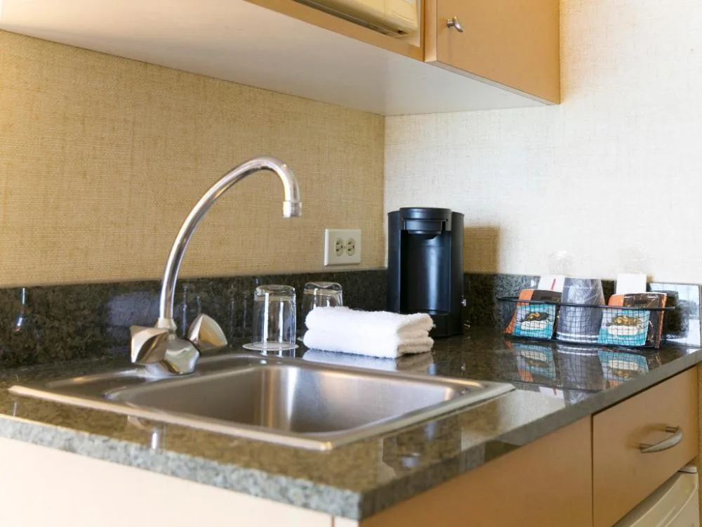 Superior Studio Suite kitchenette with sink and coffee setup at Waikiki Resort Hotel.