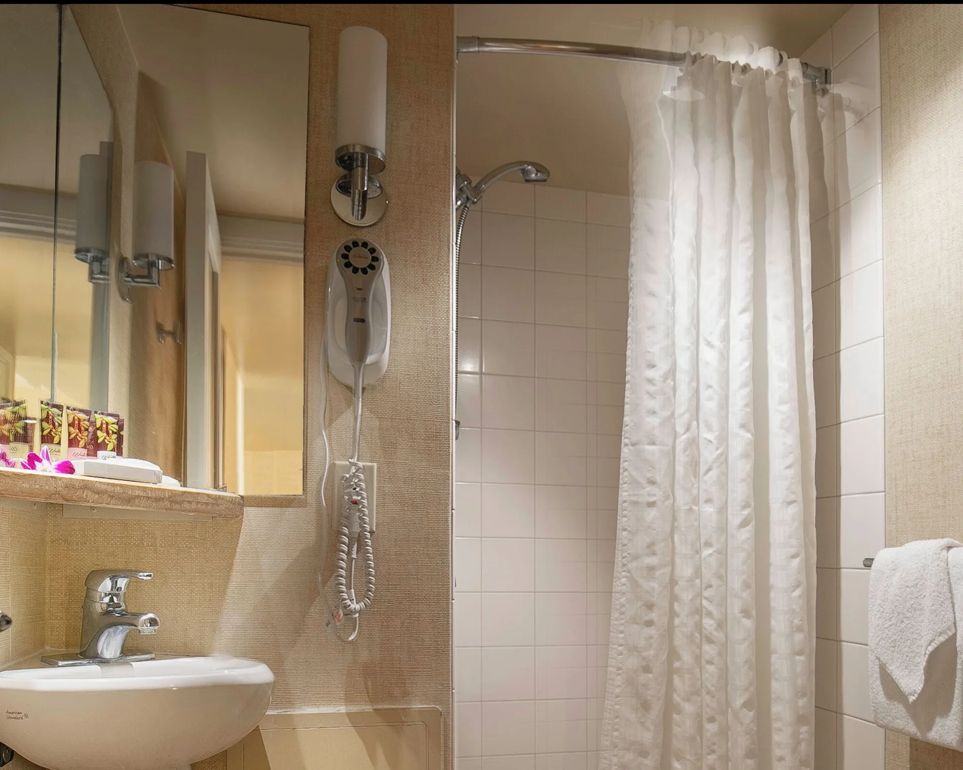 Superior Studio with Den bathroom vanity and shower at Waikiki Resort Hotel.