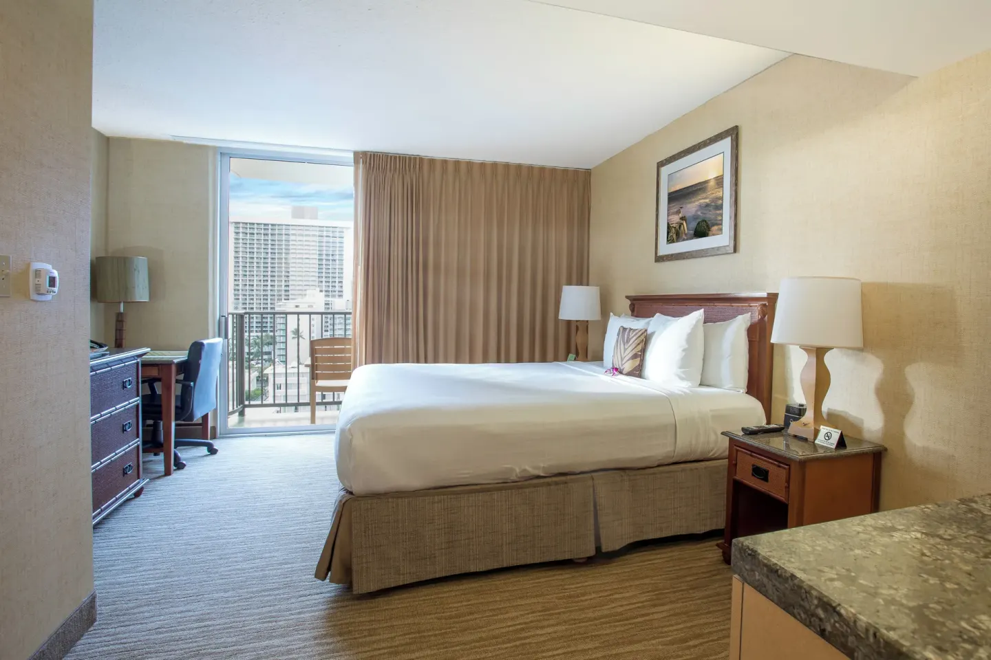 Superior Studio with Den bed, desk, and balcony door at Waikiki Resort Hotel.