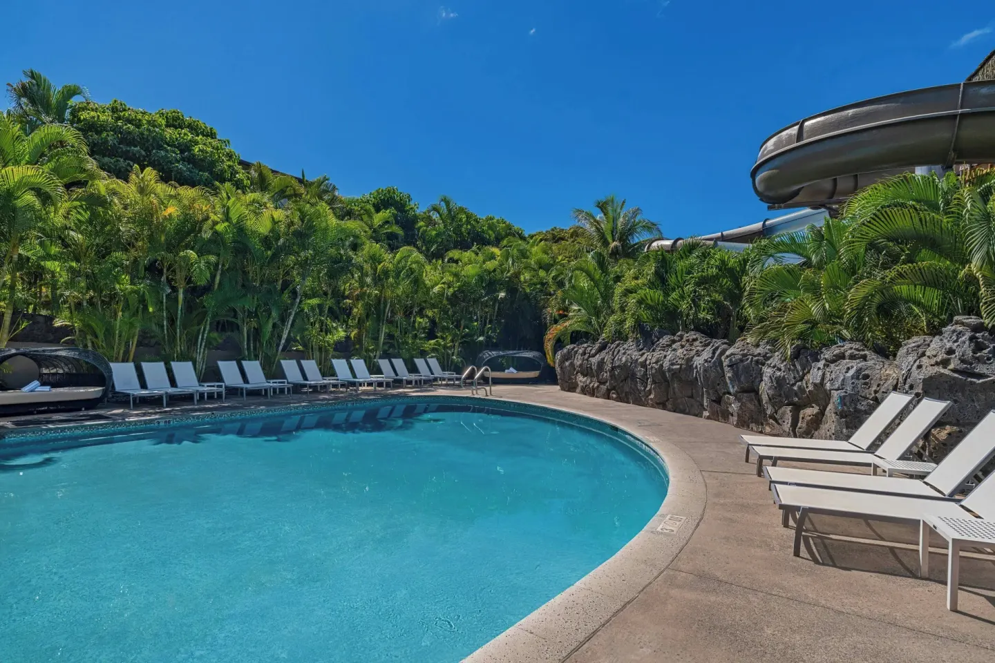 Curved resort pool with lounge chairs and waterslide at Wailea Beach Resort - Marriott, Maui.