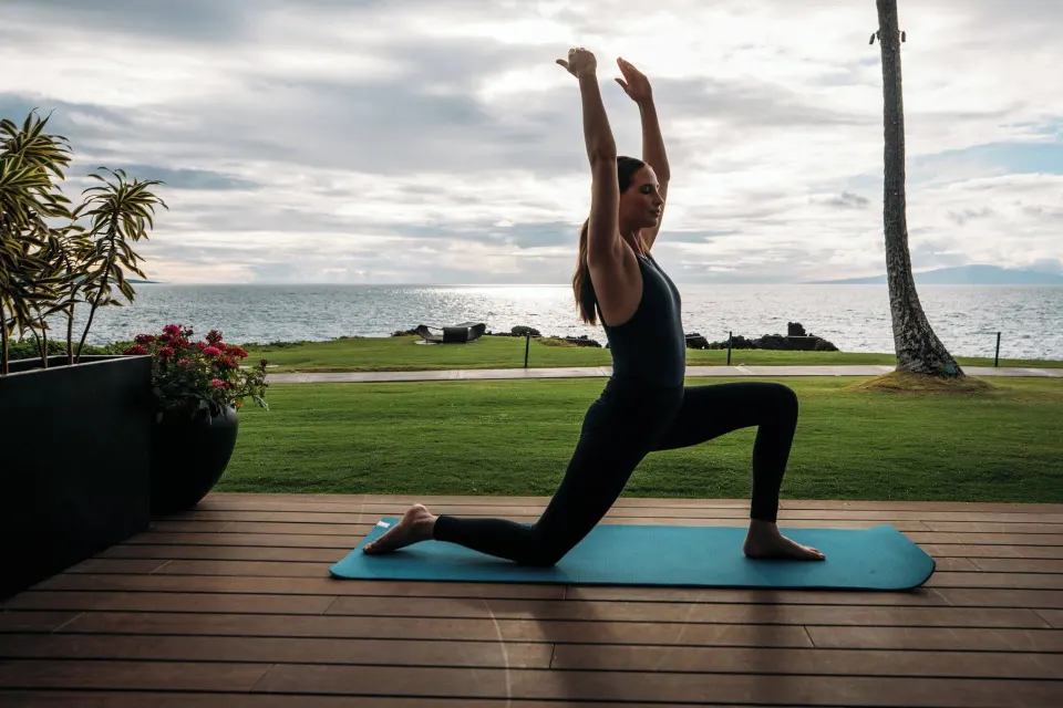 Guest practices yoga on an oceanfront deck at Wailea Beach Resort - Marriott, Maui.