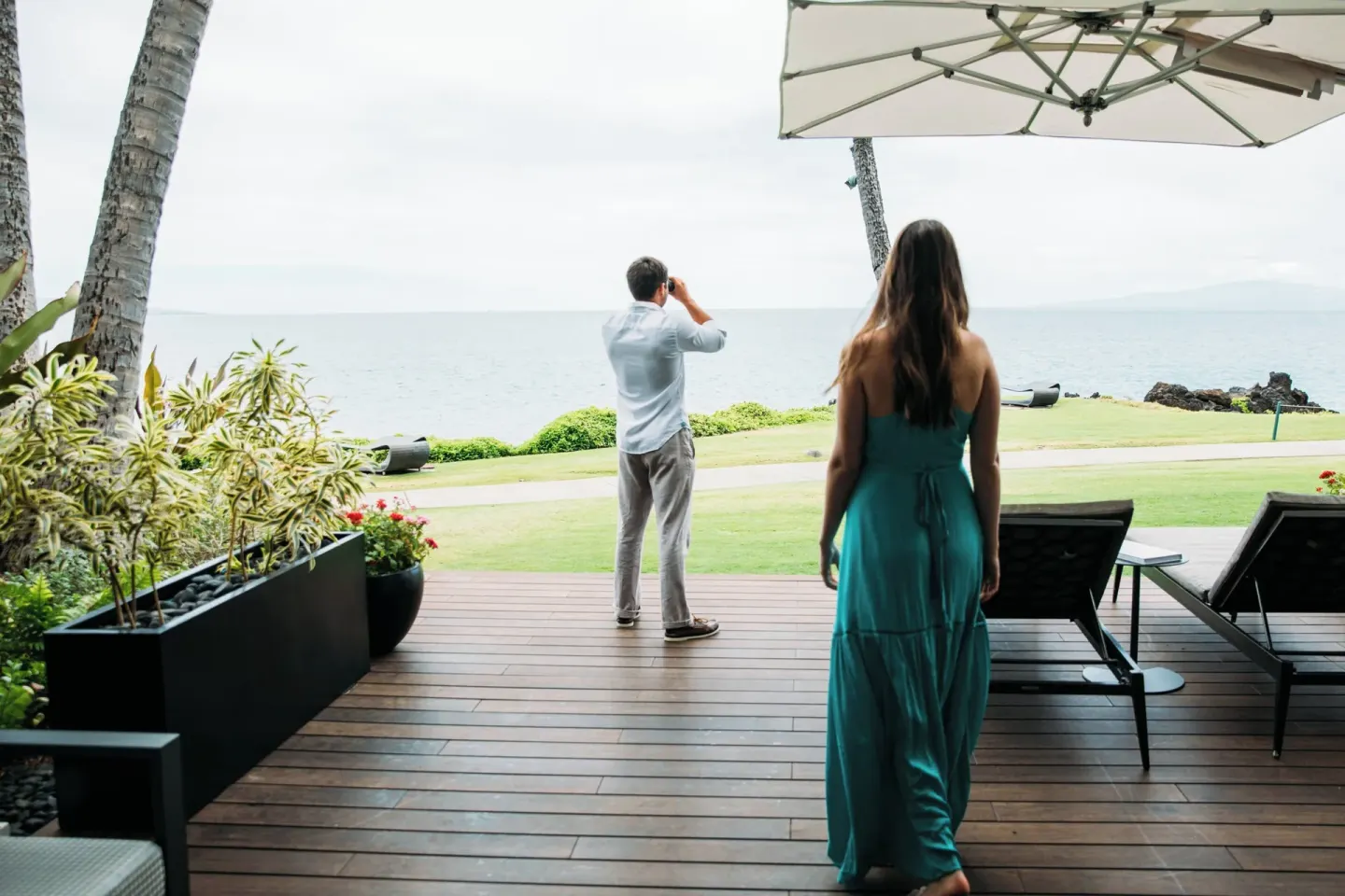 Couple looks toward the ocean from a shaded terrace at Wailea Beach Resort - Marriott, Maui.