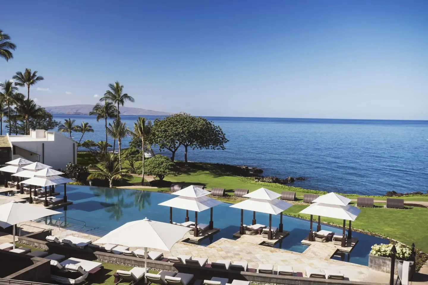 Oceanfront pool and cabanas at Wailea Beach Resort - Marriott, Maui with palms and blue water beyond.