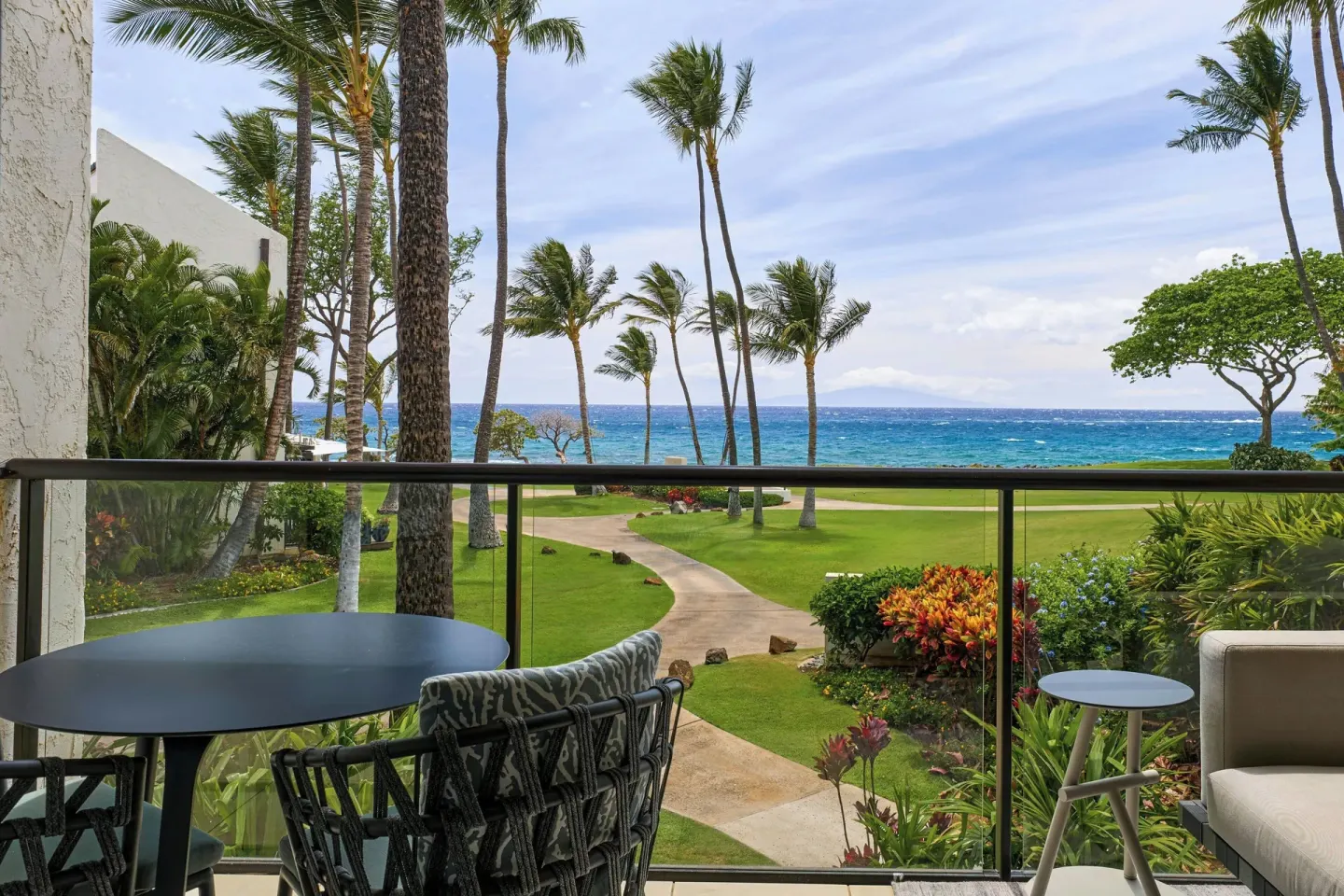 Balcony table and chairs at Wailea Beach Resort - Marriott, Maui facing palms, gardens, and ocean.
