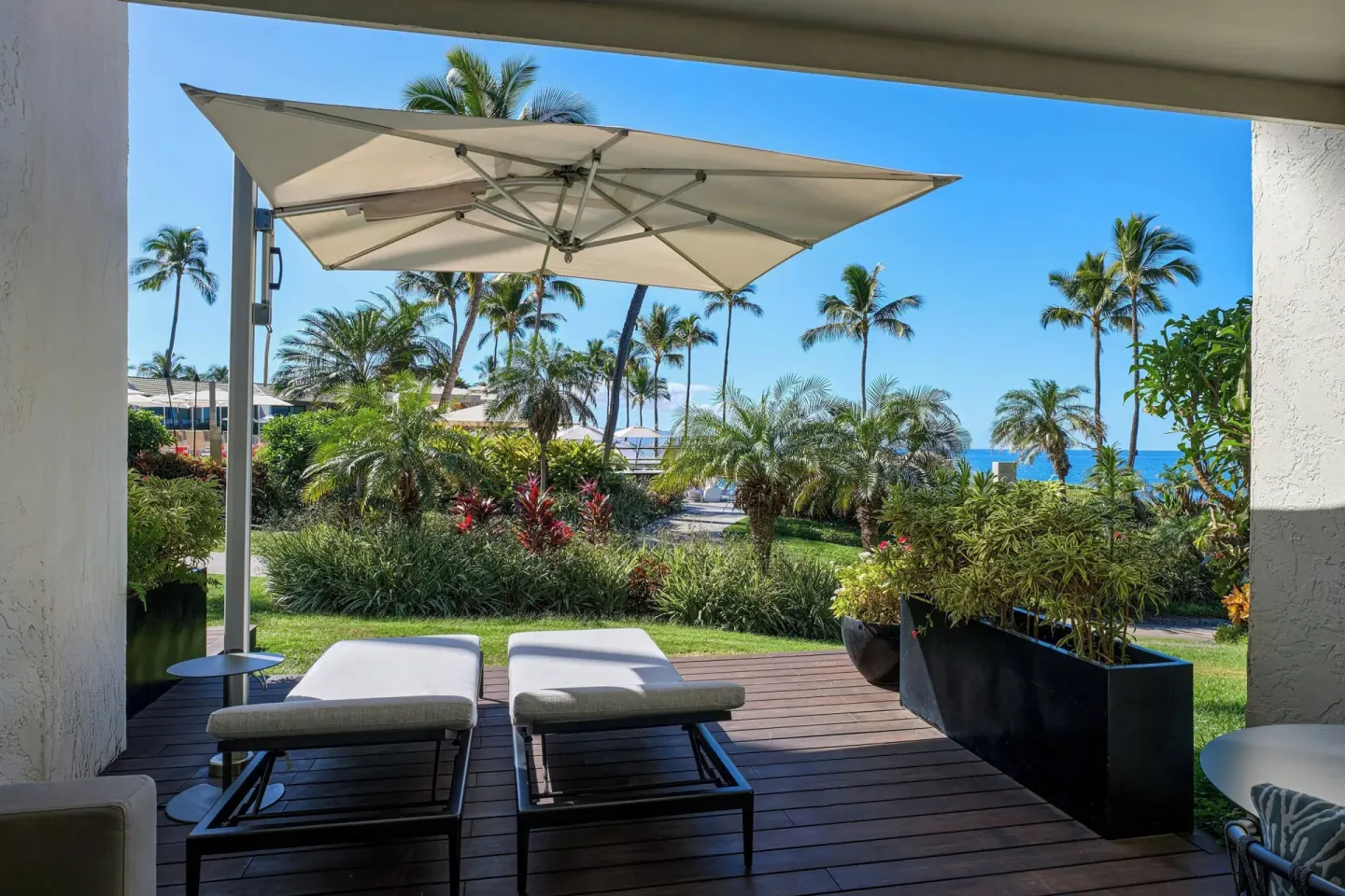 Covered lanai with loungers, umbrella, and ocean beyond at Wailea Beach Resort - Marriott, Maui.
