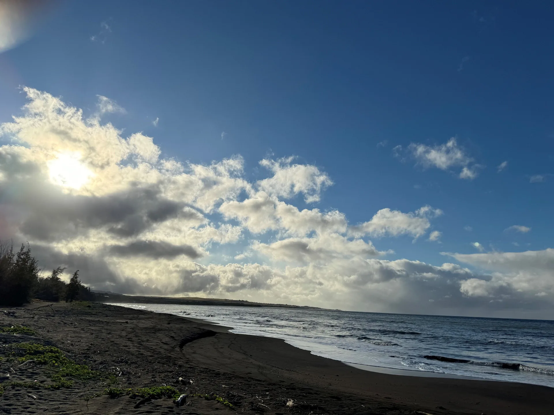 Wide beach and ocean shoreline beneath clouds near Waimea Plantation Cottages.