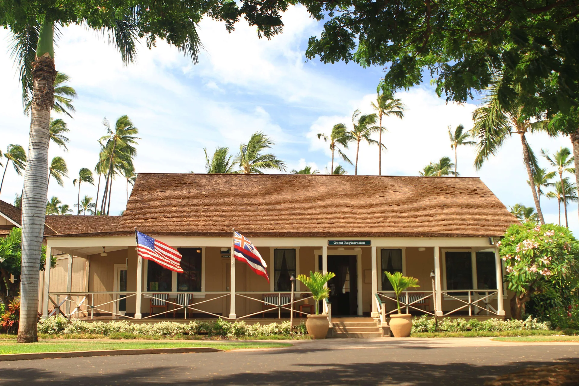Guest registration cottage with flags and palm trees at Waimea Plantation Cottages.