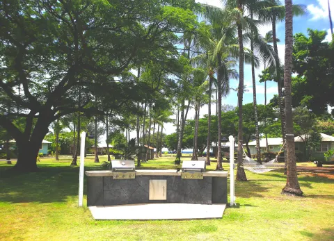 Outdoor barbecue grills and a hammock on the lawn at Waimea Plantation Cottages.