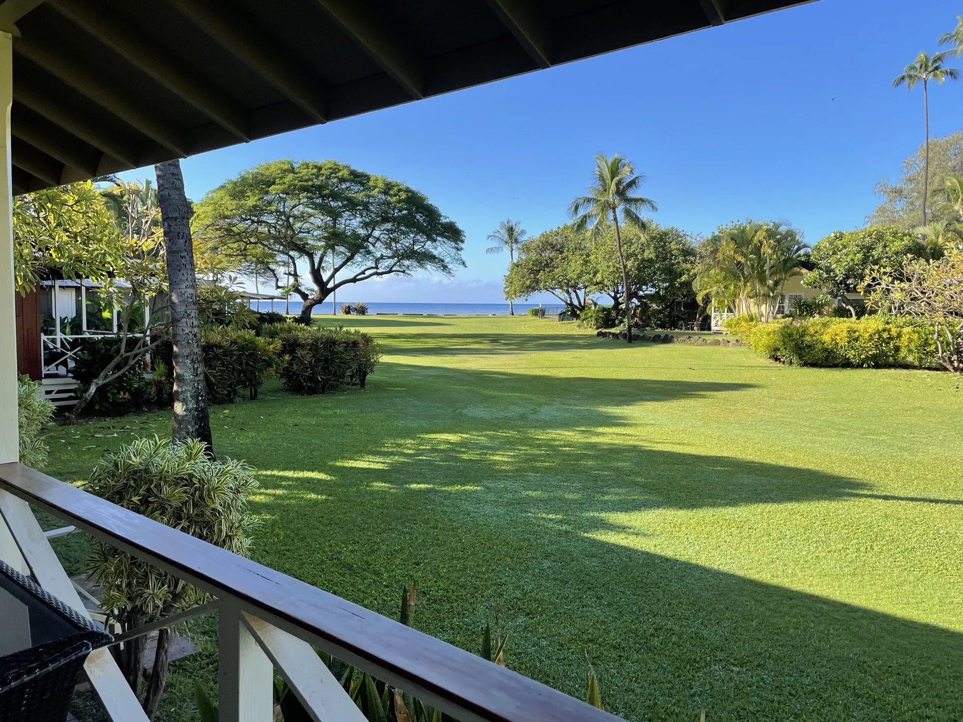 Porch view over lawn and ocean at Waimea Plantation Cottages.