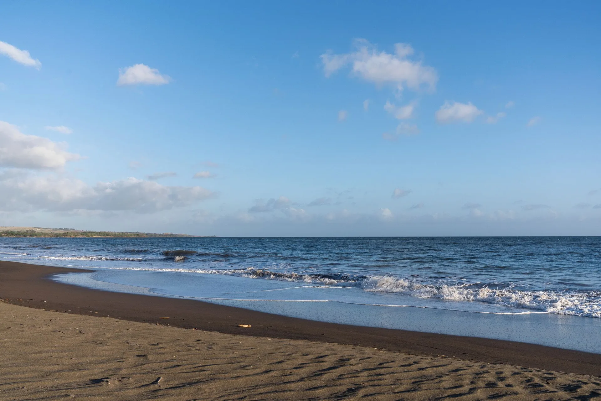 Oceanfront beach with waves near Coast Cottage at Waimea Plantation Cottages.