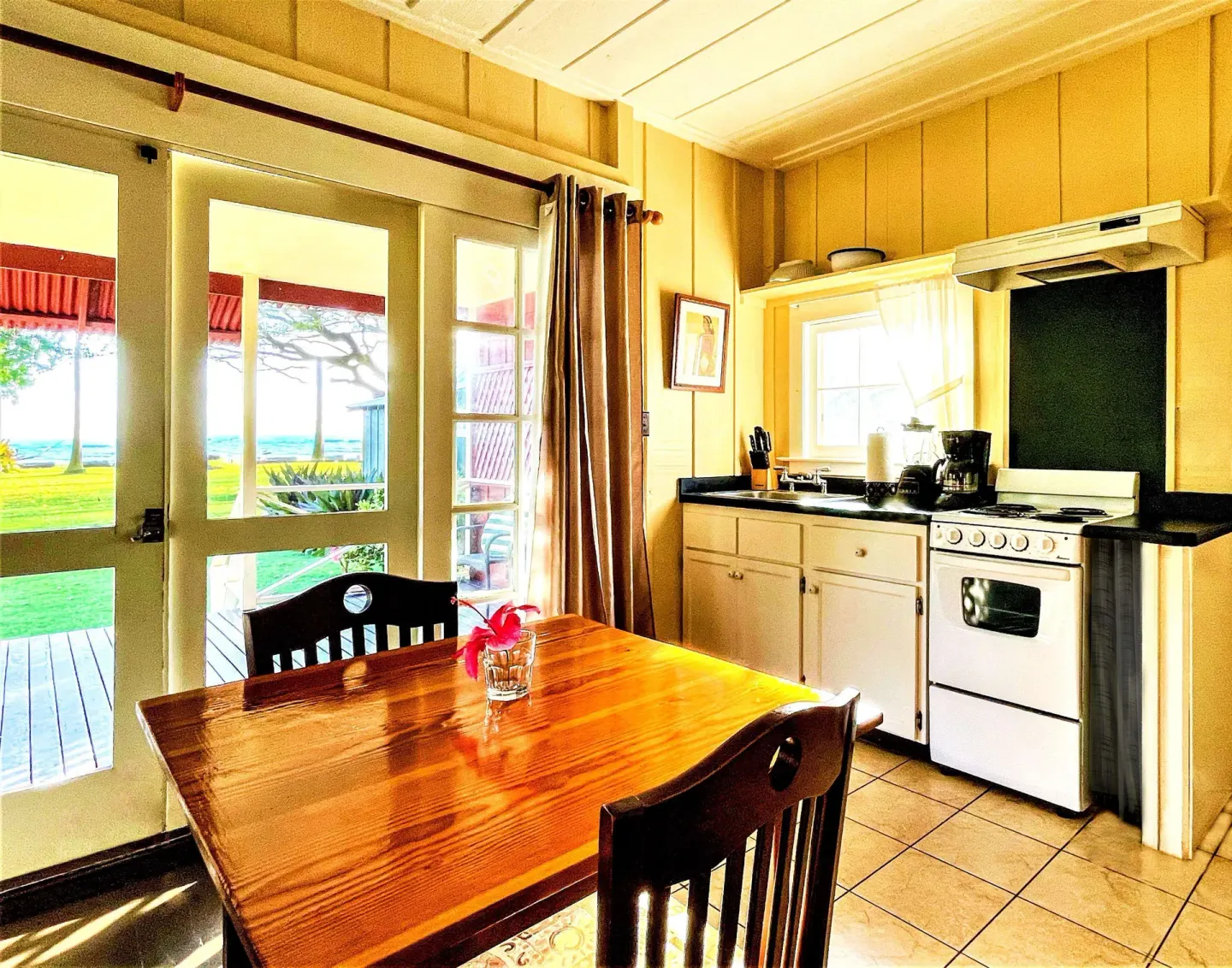 Coast Cottage kitchen and dining table with ocean beyond at Waimea Plantation Cottages.