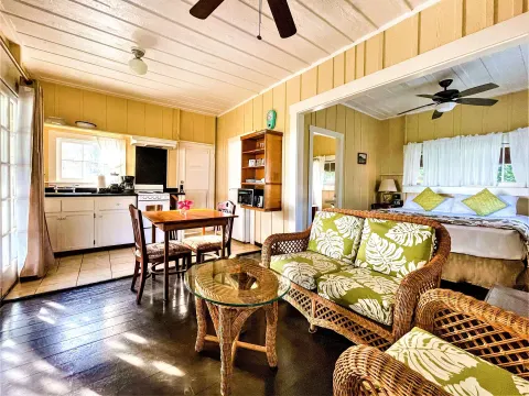 Coast Cottage living area, kitchen, and queen bed at Waimea Plantation Cottages.