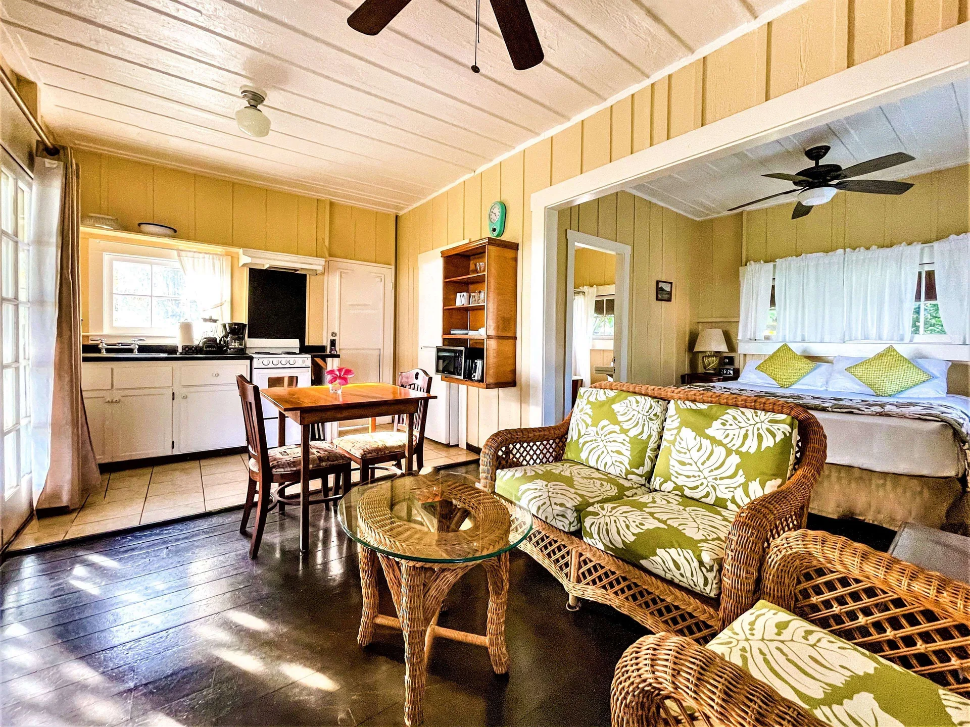 Coast Cottage living area, kitchen, and queen bed at Waimea Plantation Cottages.