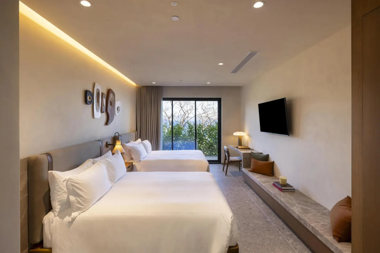 Two-bed guest room with wall art and a window view at Waldorf Astoria Costa Rica Punta Cacique.