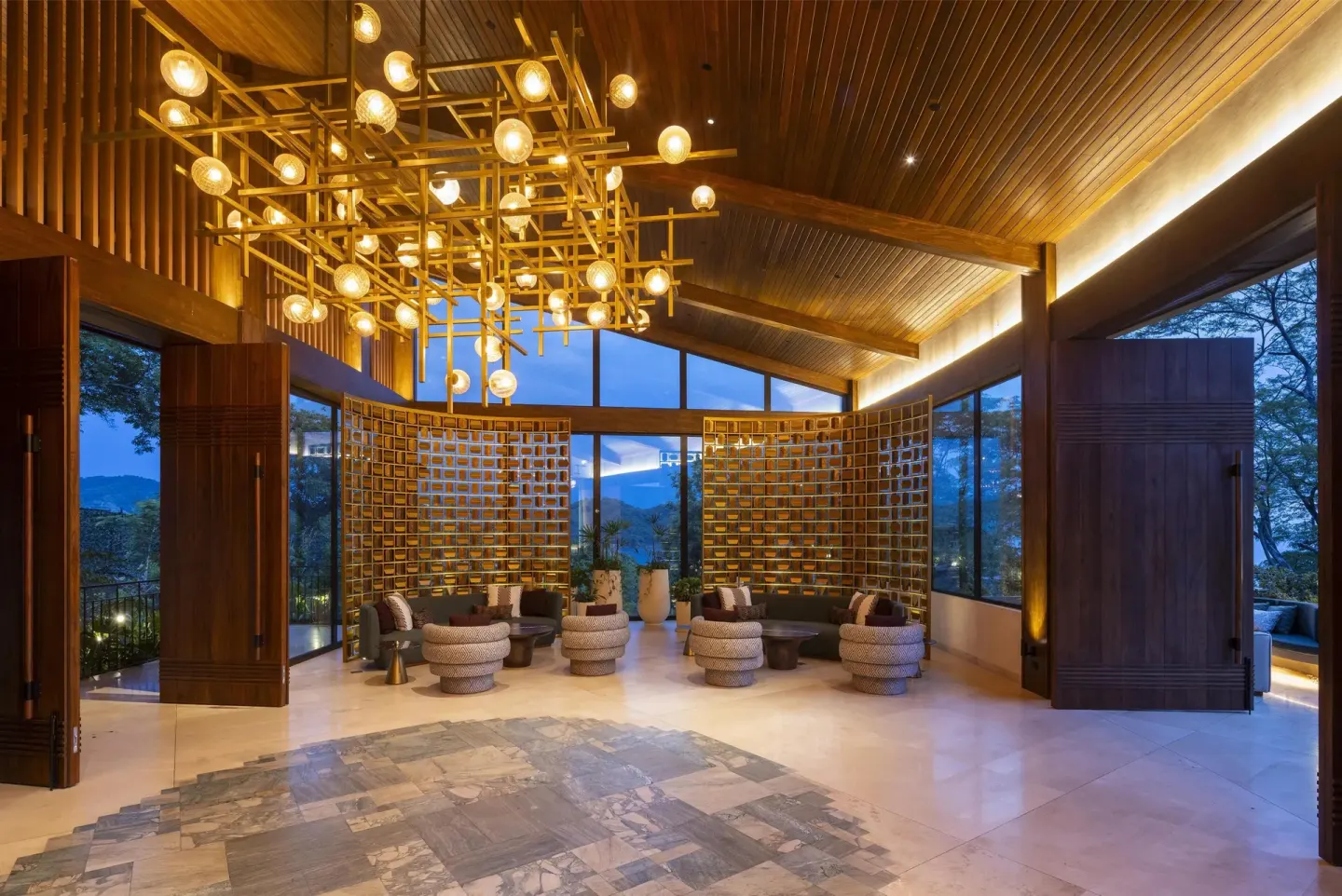Open lobby lounge with wood ceilings and globe chandeliers at Waldorf Astoria Costa Rica Punta Cacique.