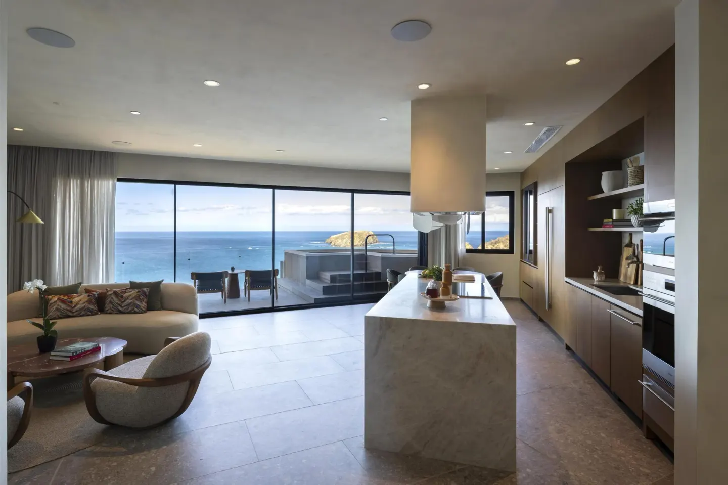 Ocean view suite with kitchen island, lounge seating and terrace at Waldorf Astoria Costa Rica Punta Cacique.