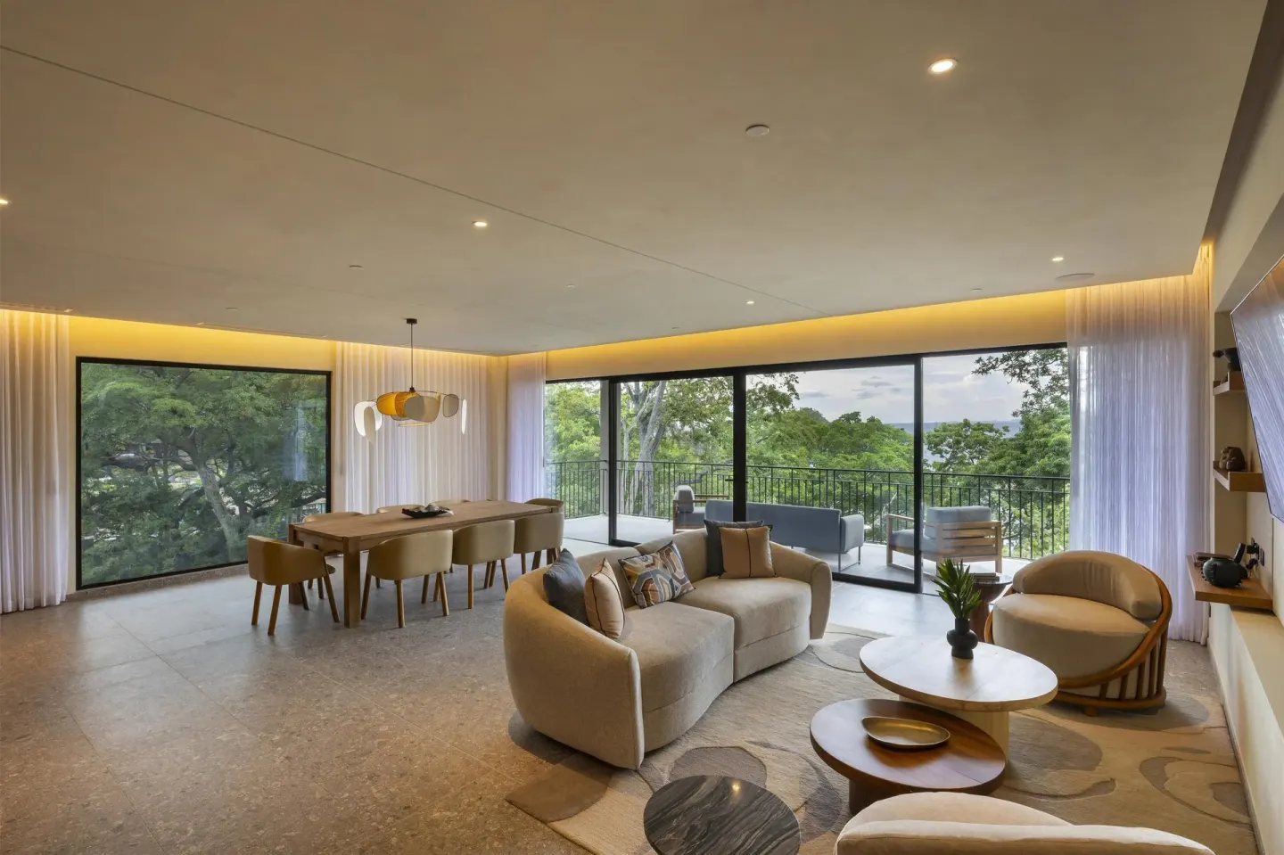 Resort suite living and dining area with balcony views at Waldorf Astoria Costa Rica Punta Cacique.