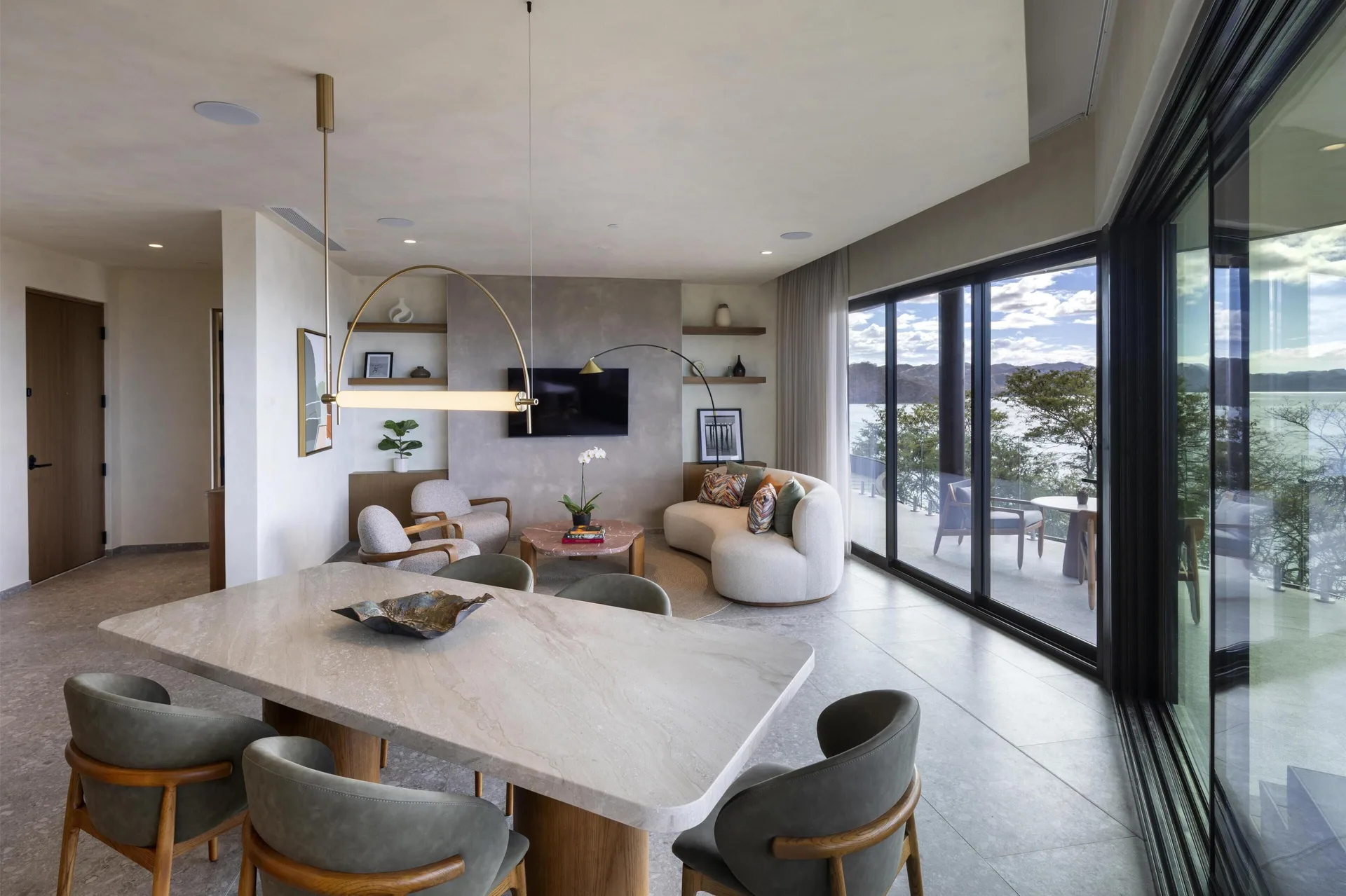 Resort suite living room with dining table and oceanfront terrace at Waldorf Astoria Costa Rica Punta Cacique.