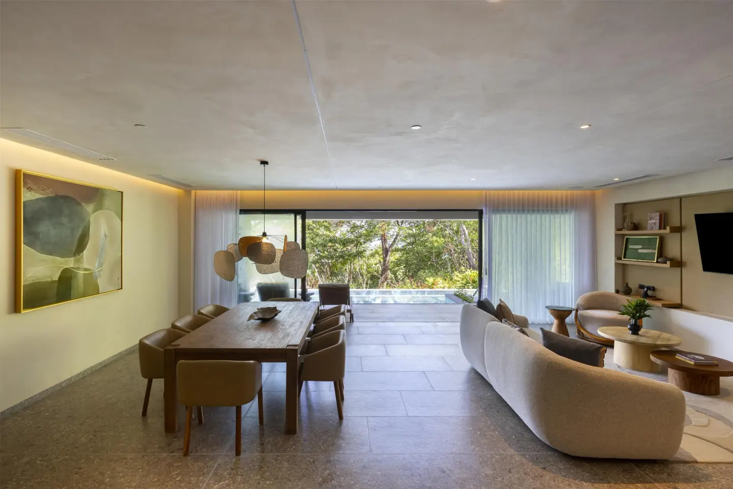 Resort suite living room with dining table and plunge pool at Waldorf Astoria Costa Rica Punta Cacique.
