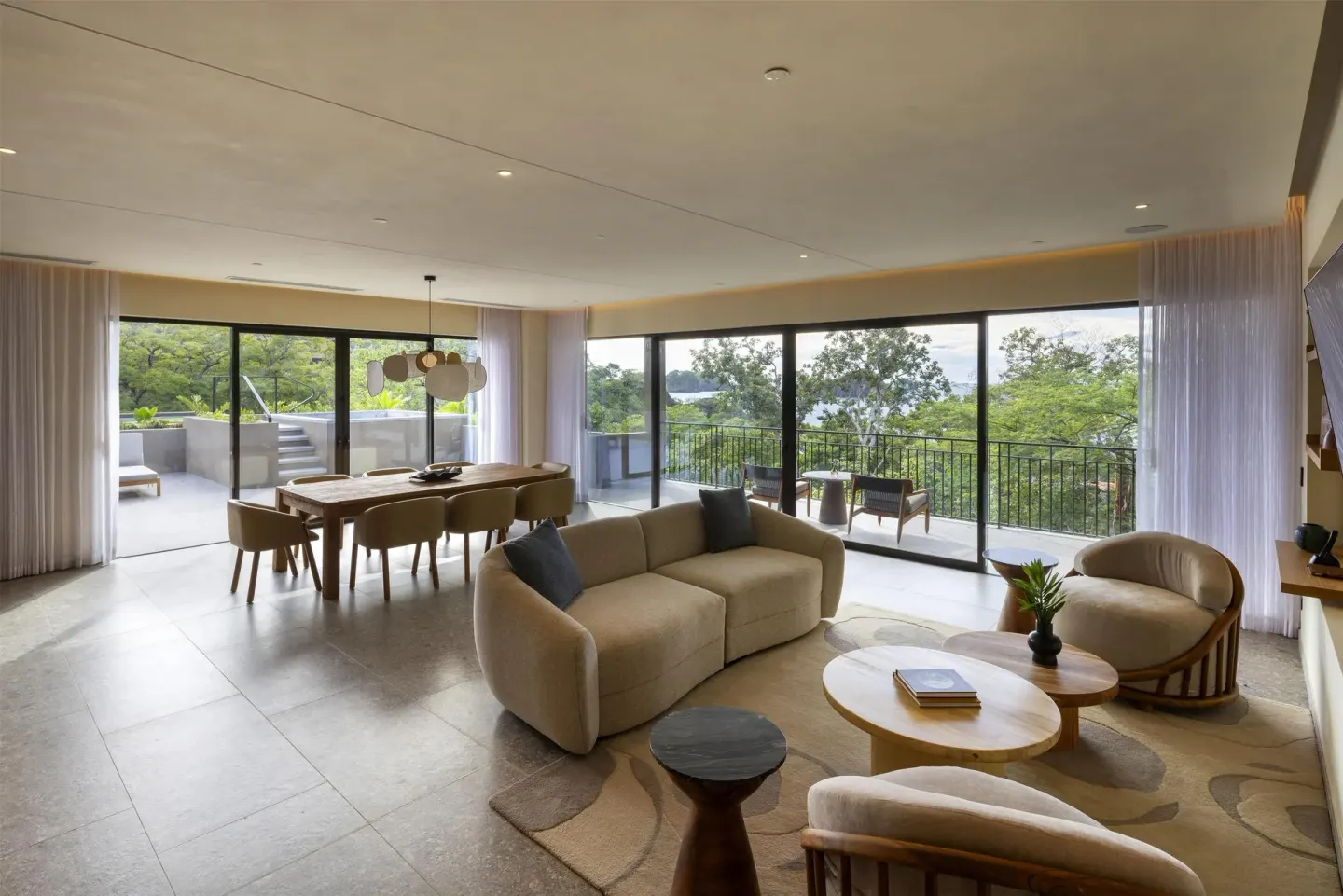 Resort suite lounge with dining area and wide balcony doors at Waldorf Astoria Costa Rica Punta Cacique.