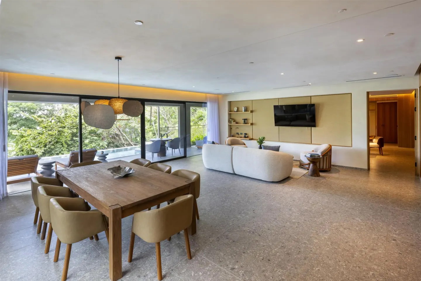 Suite dining table and living area beside a wooded terrace at Waldorf Astoria Costa Rica Punta Cacique.