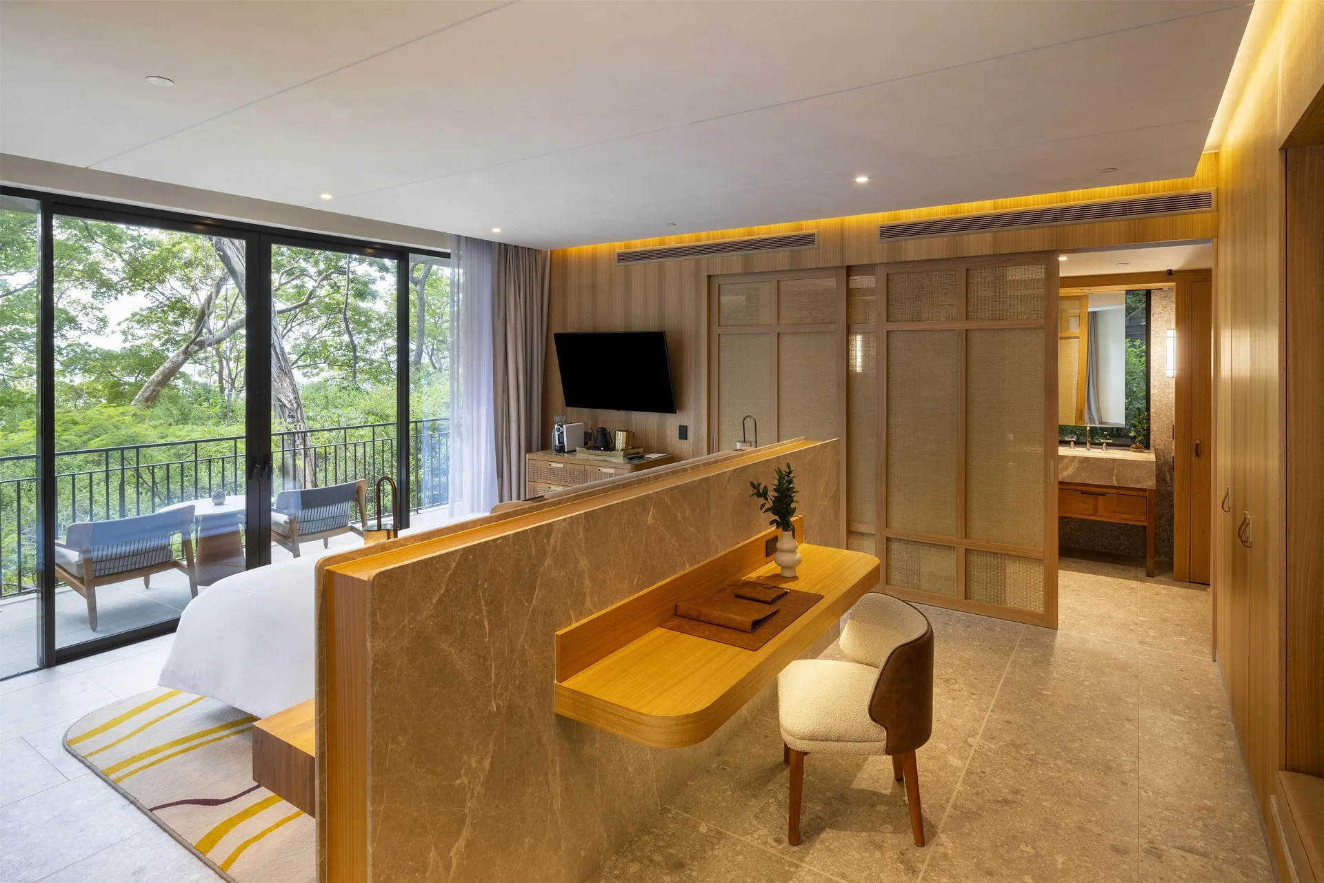 Suite entry, desk, king bed, and forest balcony at Waldorf Astoria Costa Rica Punta Cacique.