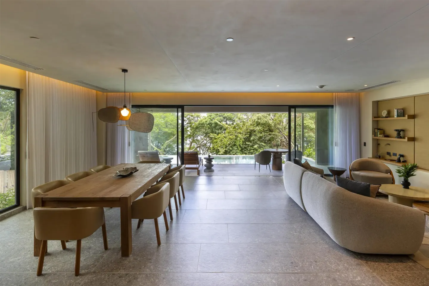 Suite living and dining room opening to a green terrace at Waldorf Astoria Costa Rica Punta Cacique.