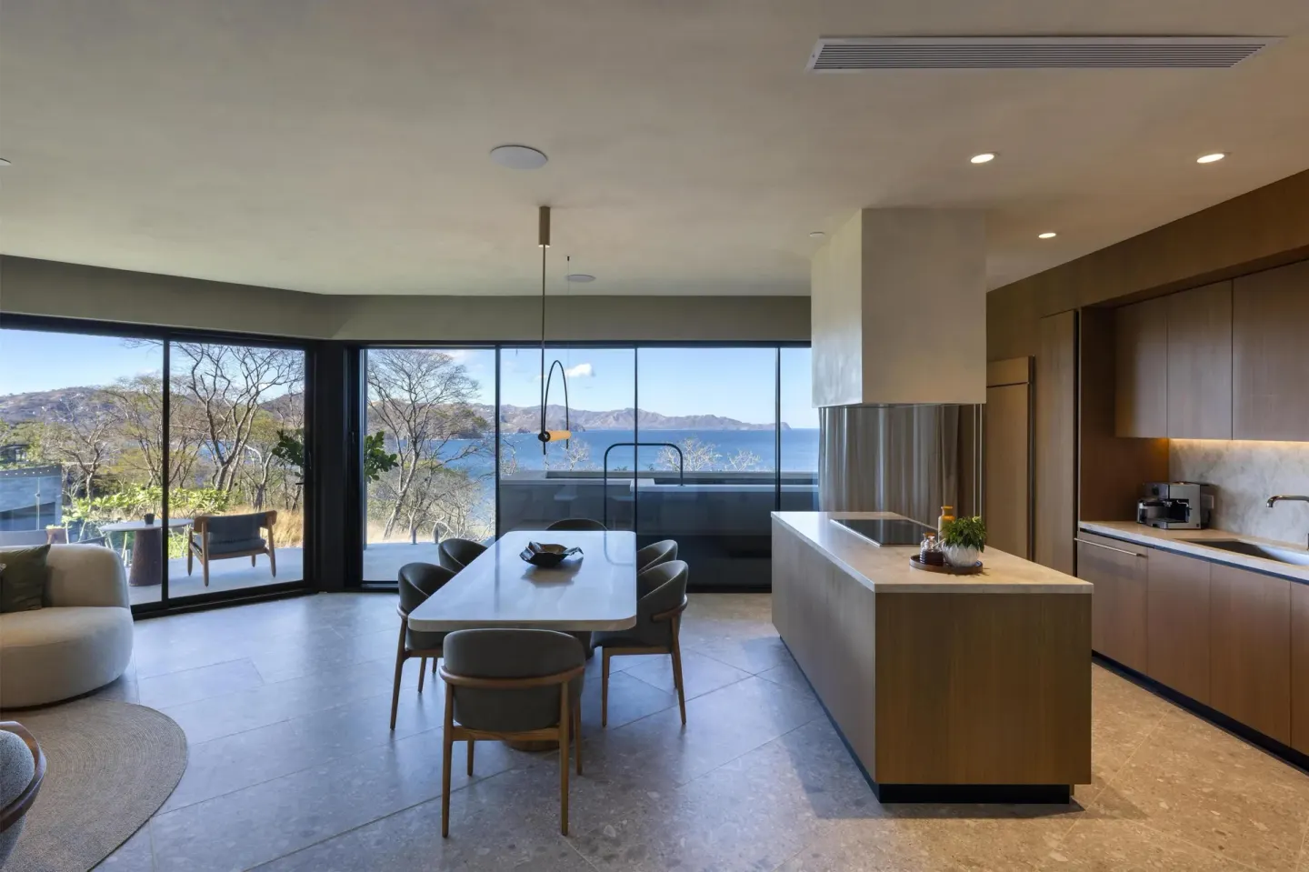 Suite living and kitchen area with ocean-facing glass doors at Waldorf Astoria Costa Rica Punta Cacique.