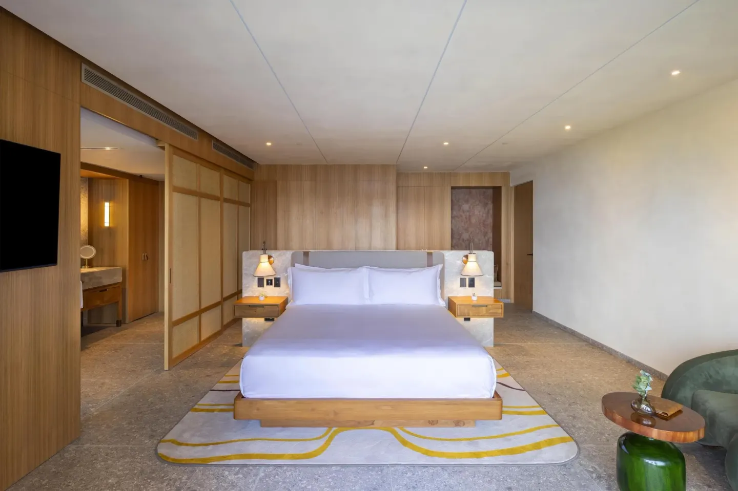 King guest room with wood paneling and open bathroom entry at Waldorf Astoria Costa Rica Punta Cacique.