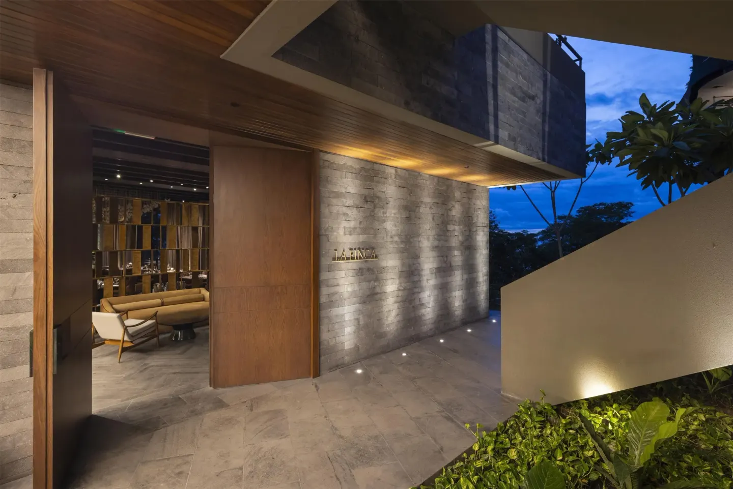 La Finca entrance with illuminated wall sign at Waldorf Astoria Costa Rica Punta Cacique.