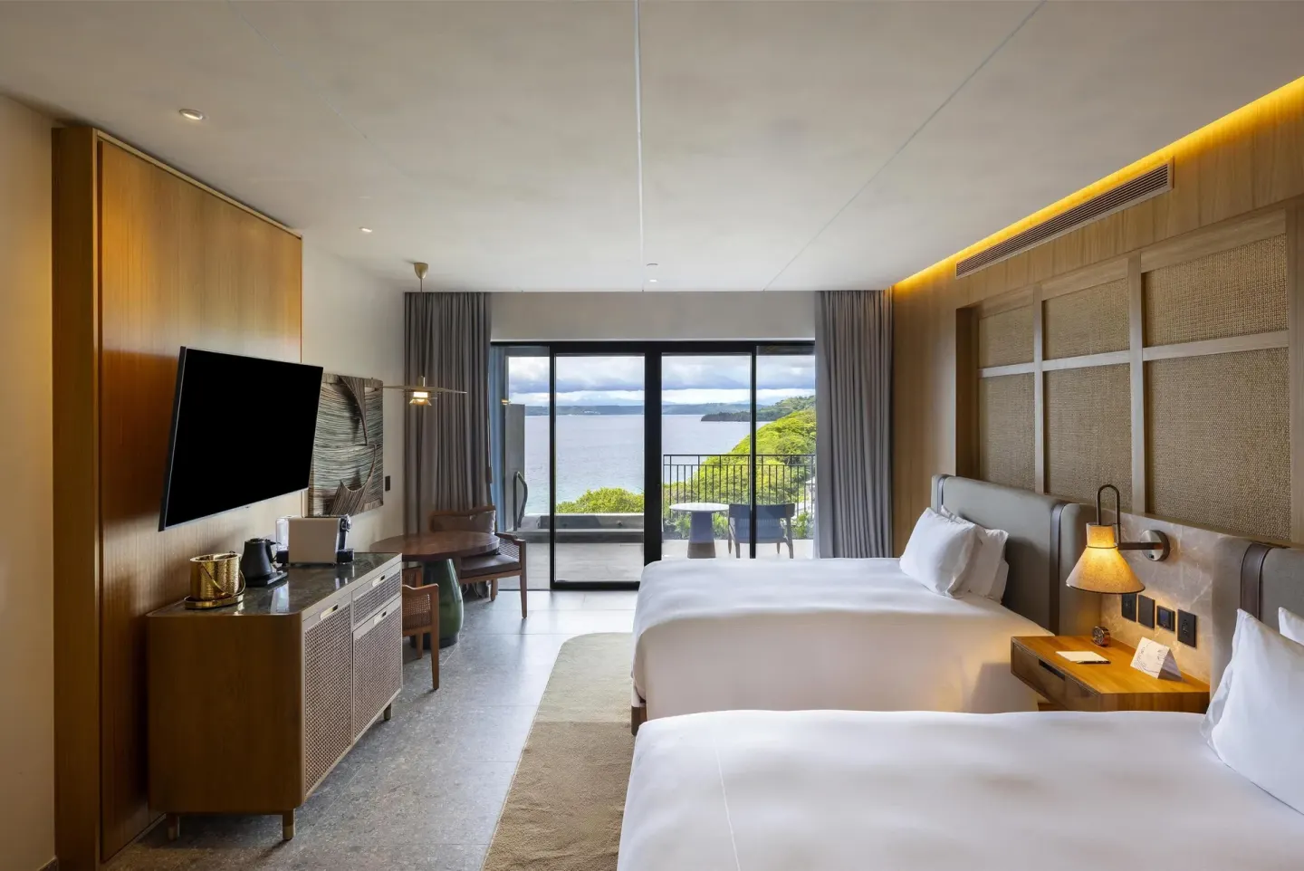 Two queen beds in a Bahia View room at Waldorf Astoria Costa Rica Punta Cacique with balcony and bay view.