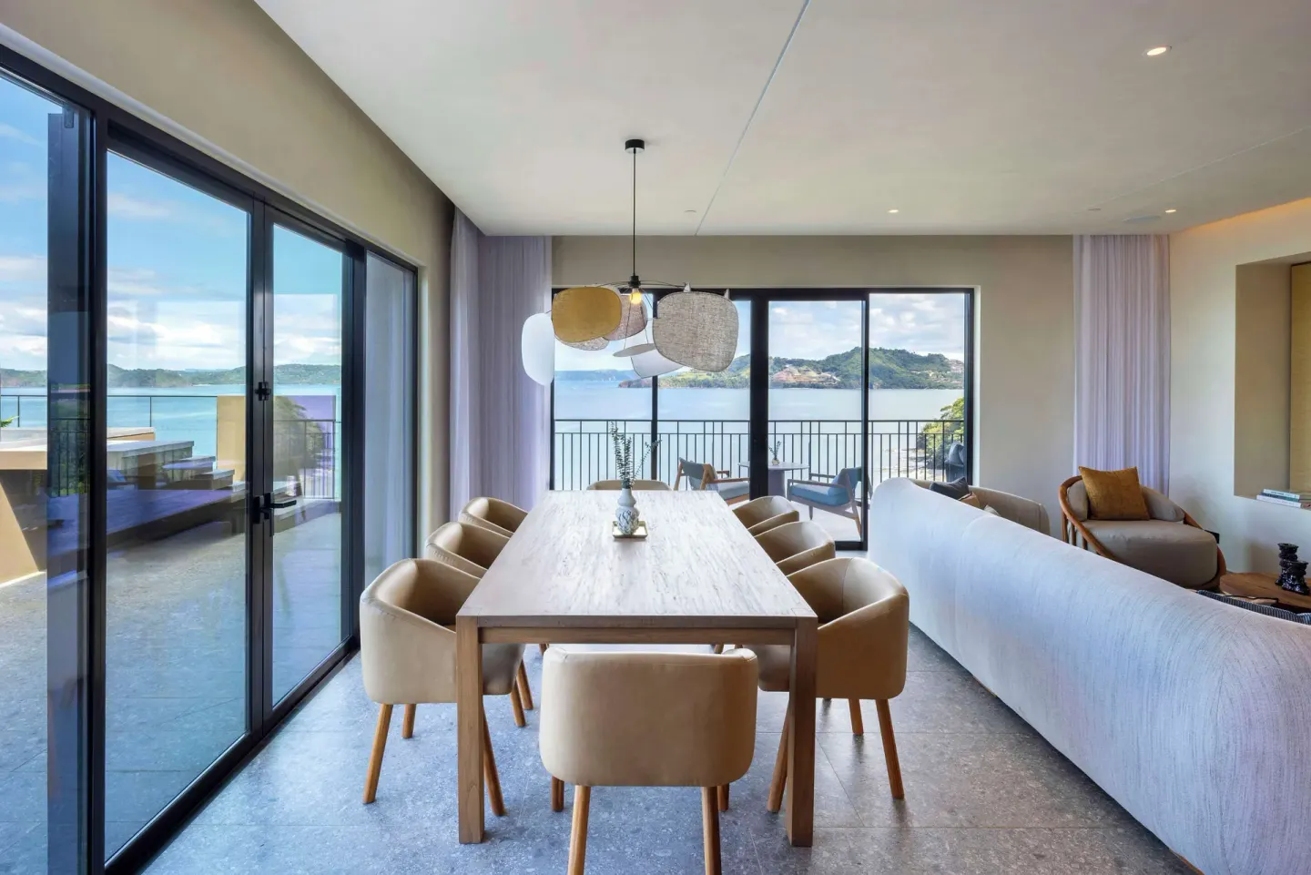 Dining table beside sliding glass doors in an ocean-view suite at Waldorf Astoria Costa Rica Punta Cacique.